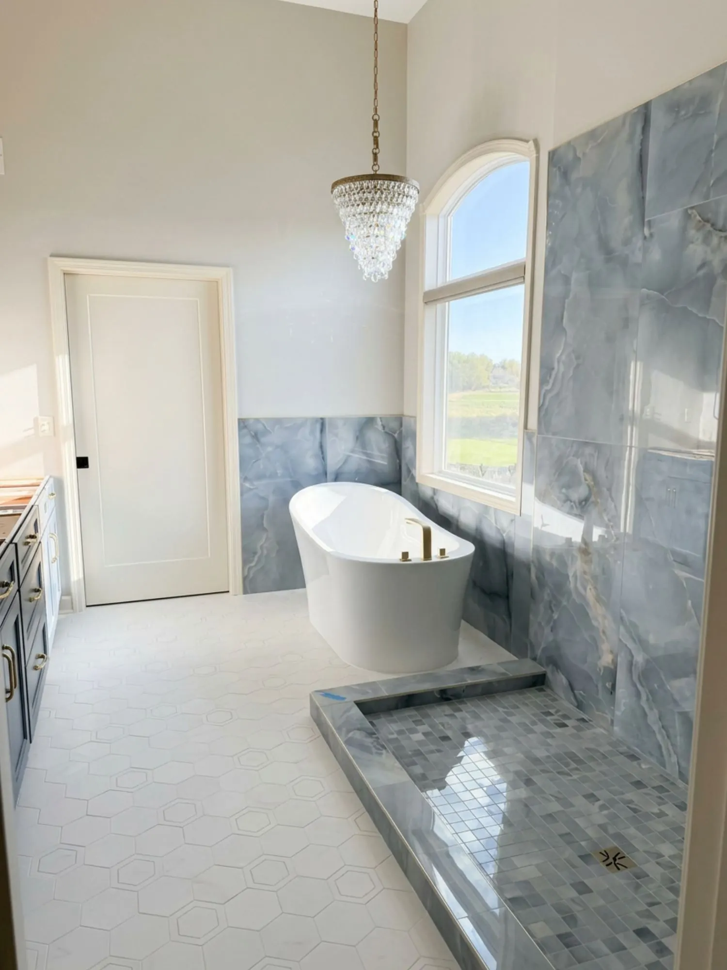 Primary bathroom remodel in Lee’s Summit, MO with dramatic stone walls and freestanding tub Primary bathroom remodel in Lee’s Summit, MO with dramatic stone walls and freestanding tub
